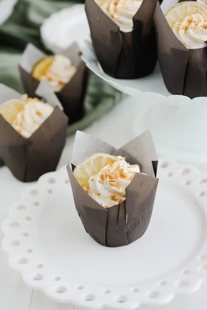 Key Lime Pie Cupcake on a white plate with cupcakes in background.