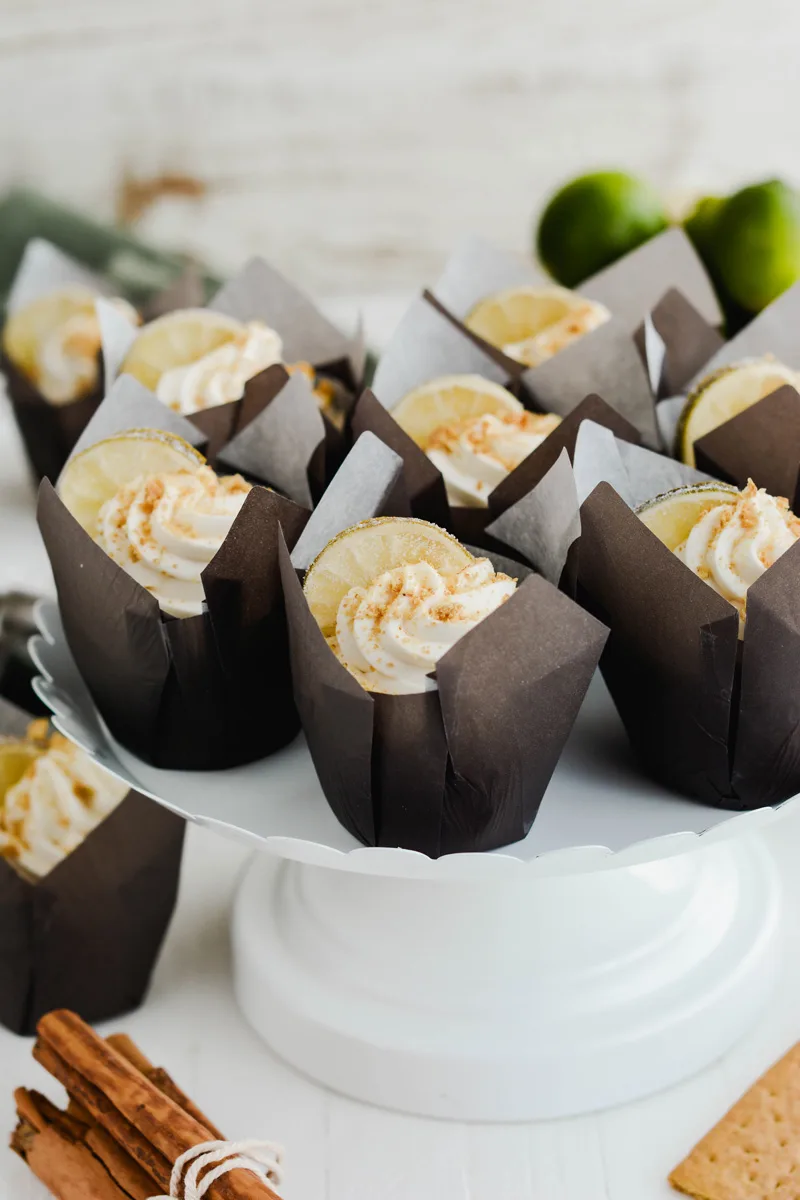 Key Lime Pie Cupcakes on white cake pedestal.