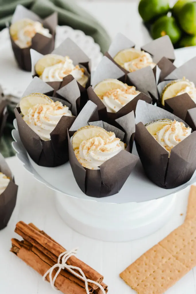 Three quarter angle Key Lime Pie Cupcakes on white cake pedestal.