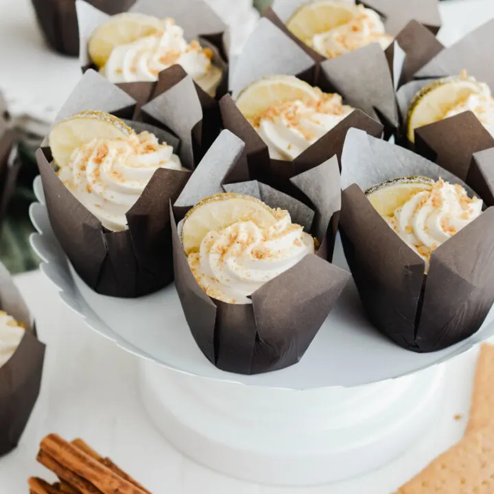 Three quarter angle Key Lime Pie Cupcakes on white cake pedestal.