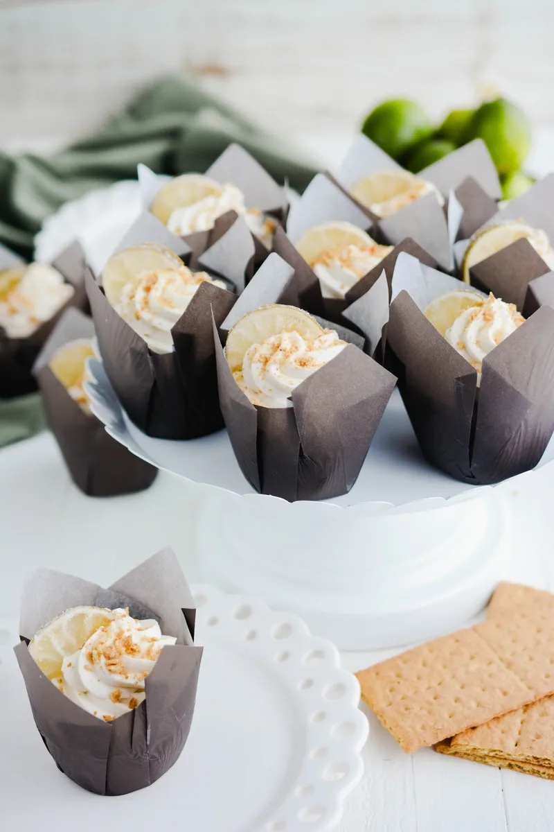 Wide open shot of Key Lime Pie Cupcakes on white cake pedestal.