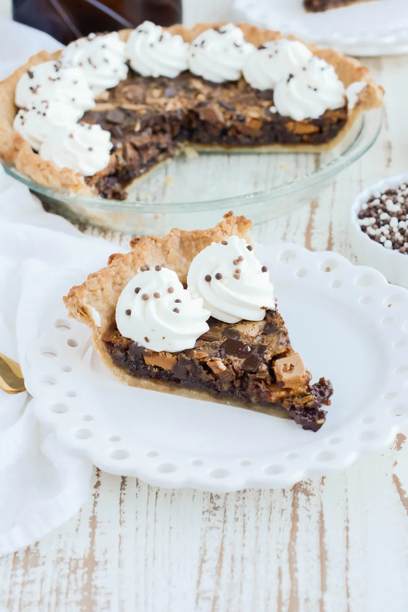 Close up shot of sliced Chocolate Chunk Pecan Pie on white plate.