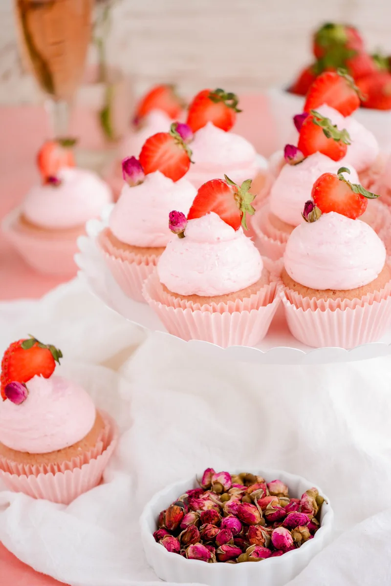 Strawberry Rose Cupcakes on white cake pedestal.