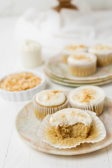 Three quarter angle of Protein Coconut Cupcakes with a bite.