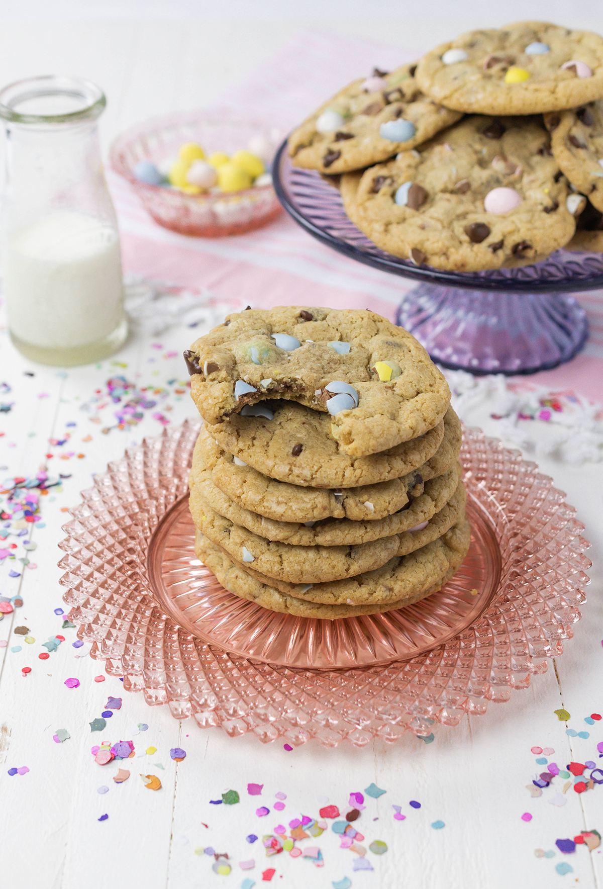 Three quarter angle stacked Easy Easter Egg Chocolate Chip Cookies on pink plate with a bite.