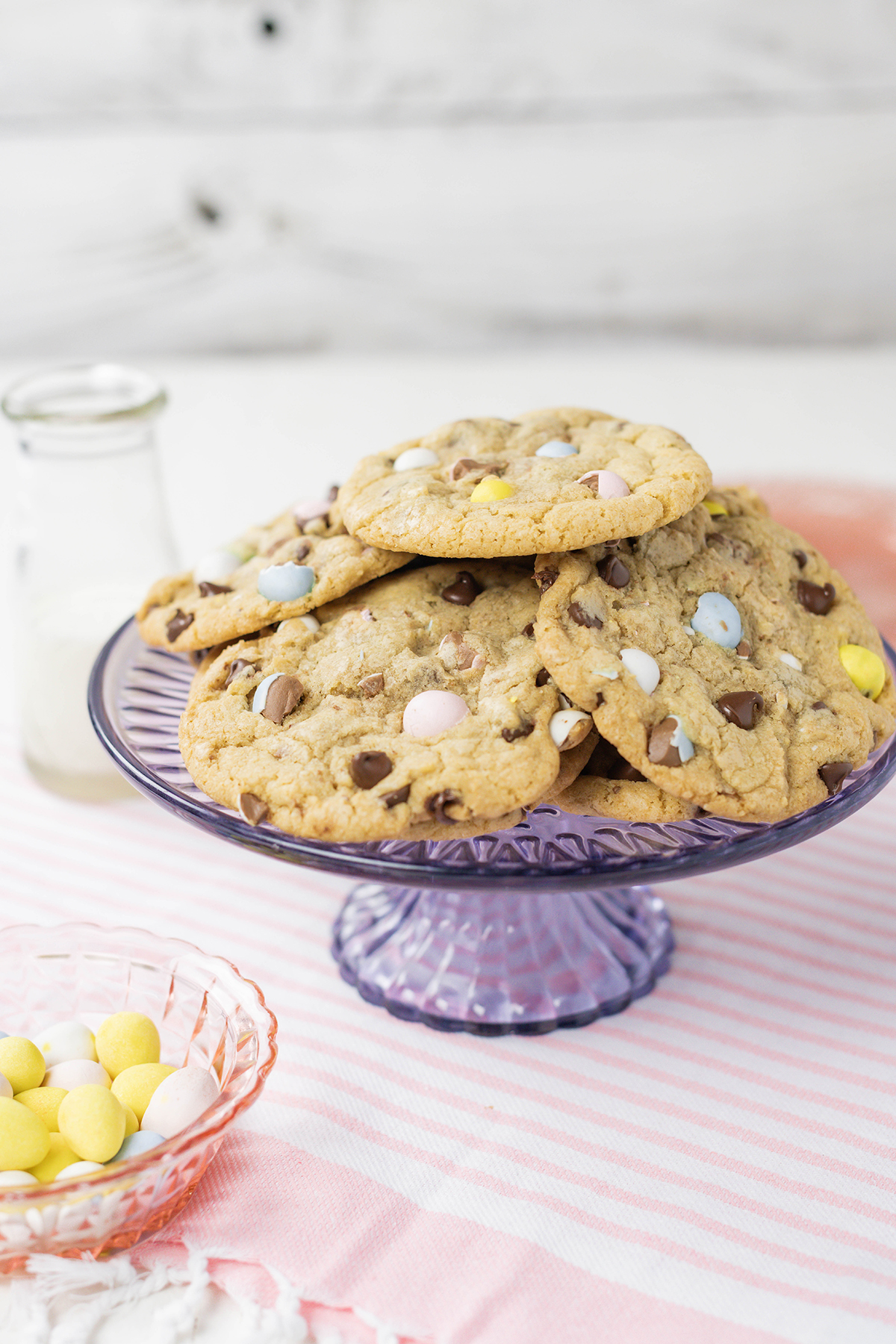 Three quarter angle of Easy Easter Egg Chocolate Chip Cookies on a purple cake pedestal.