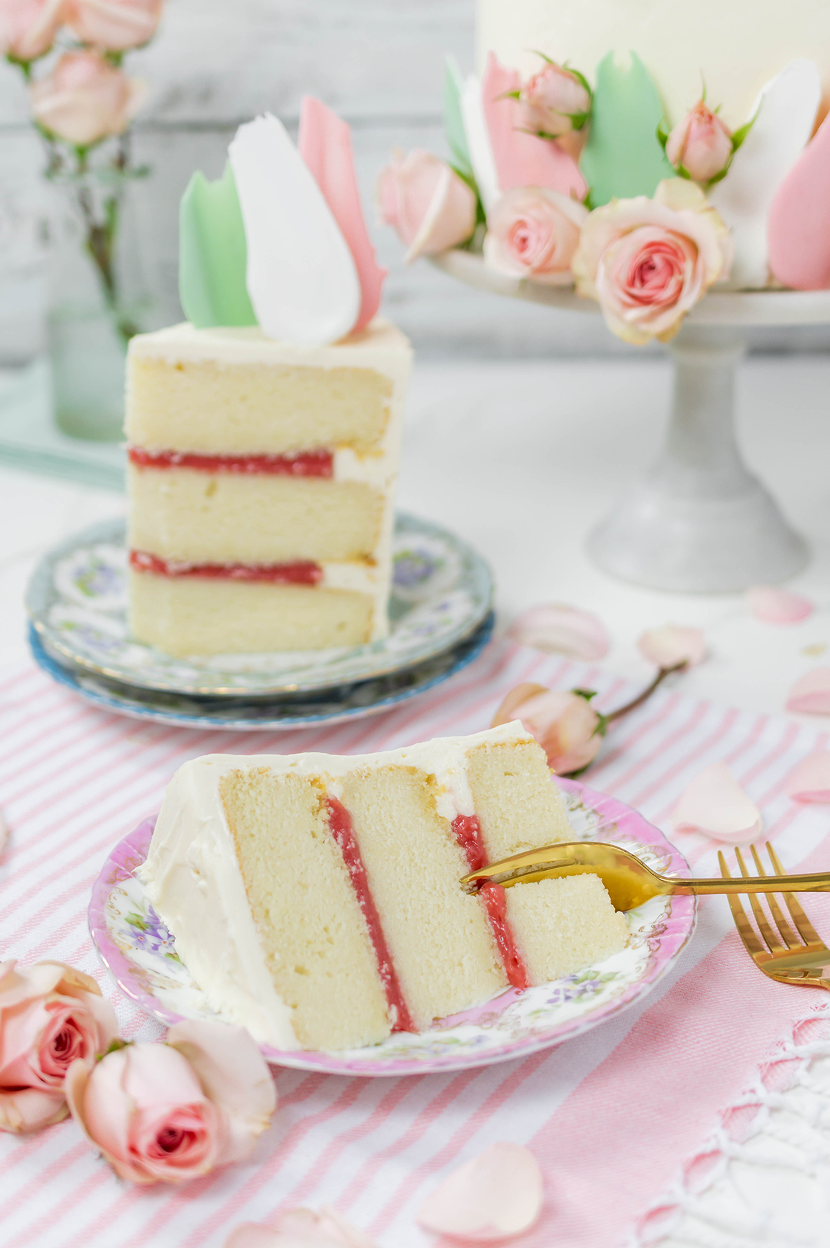 Sliced Blooms and Brushstrokes Vanilla Strawberry Cake on plates.
