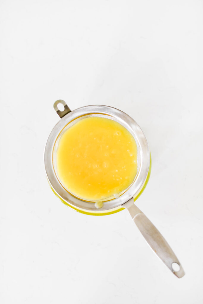 Overhead shot of lemon curd in sieve for Lavender Lemon Cupcakes.