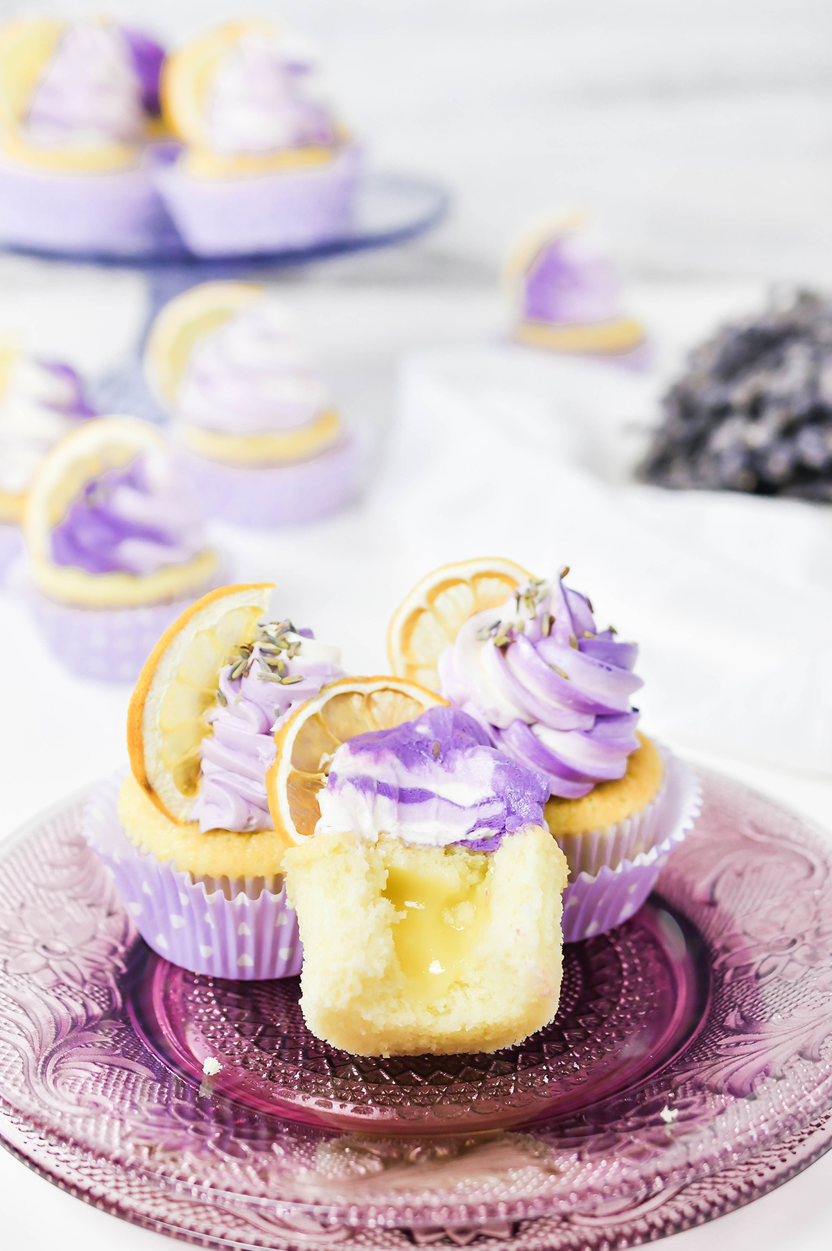 Close up shot of half eaten Lavender Lemon Cupcake with lemon curd filling.
