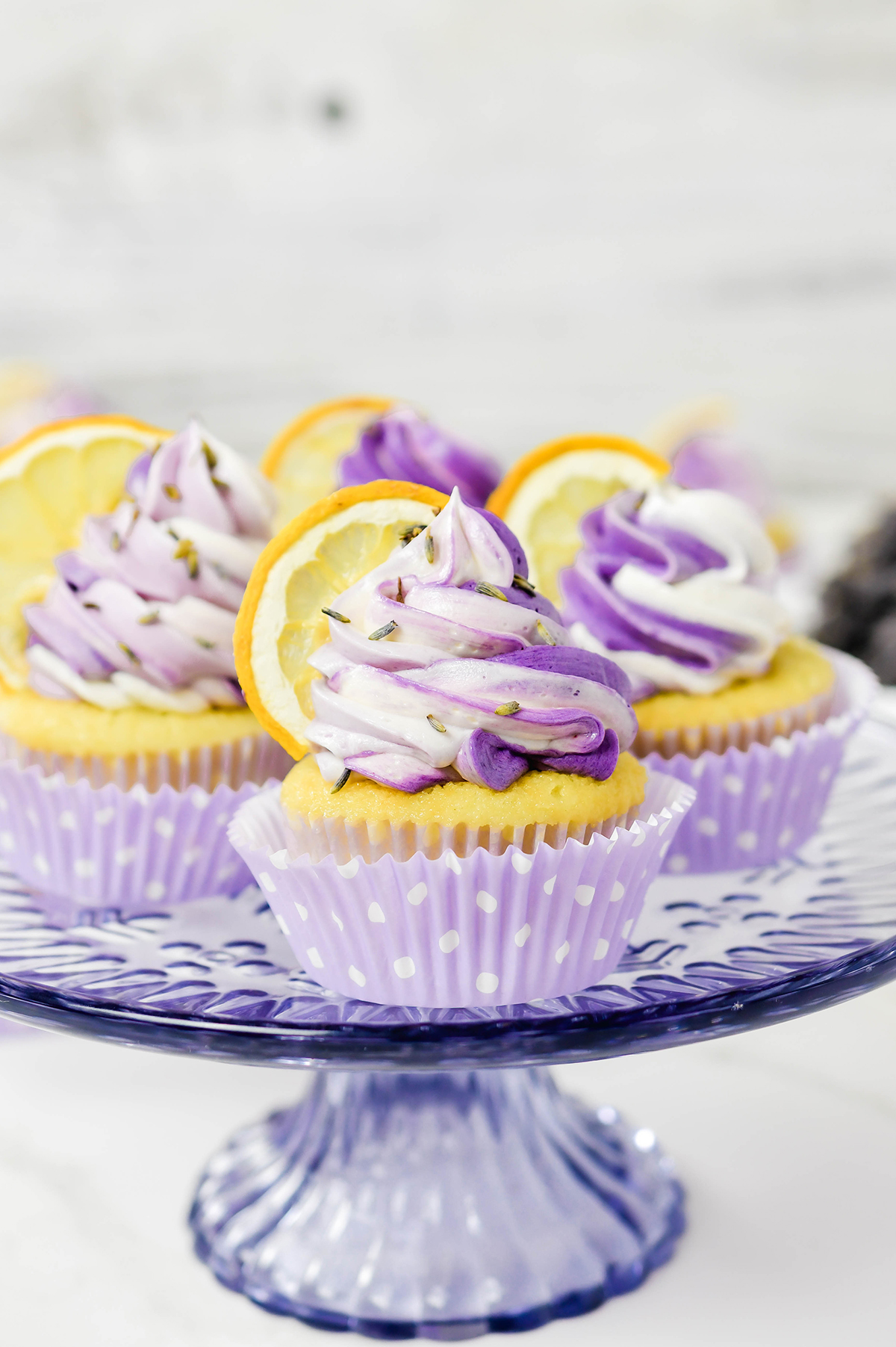 Close up of Lavender Lemon Cupcakes on lavender cake plate.