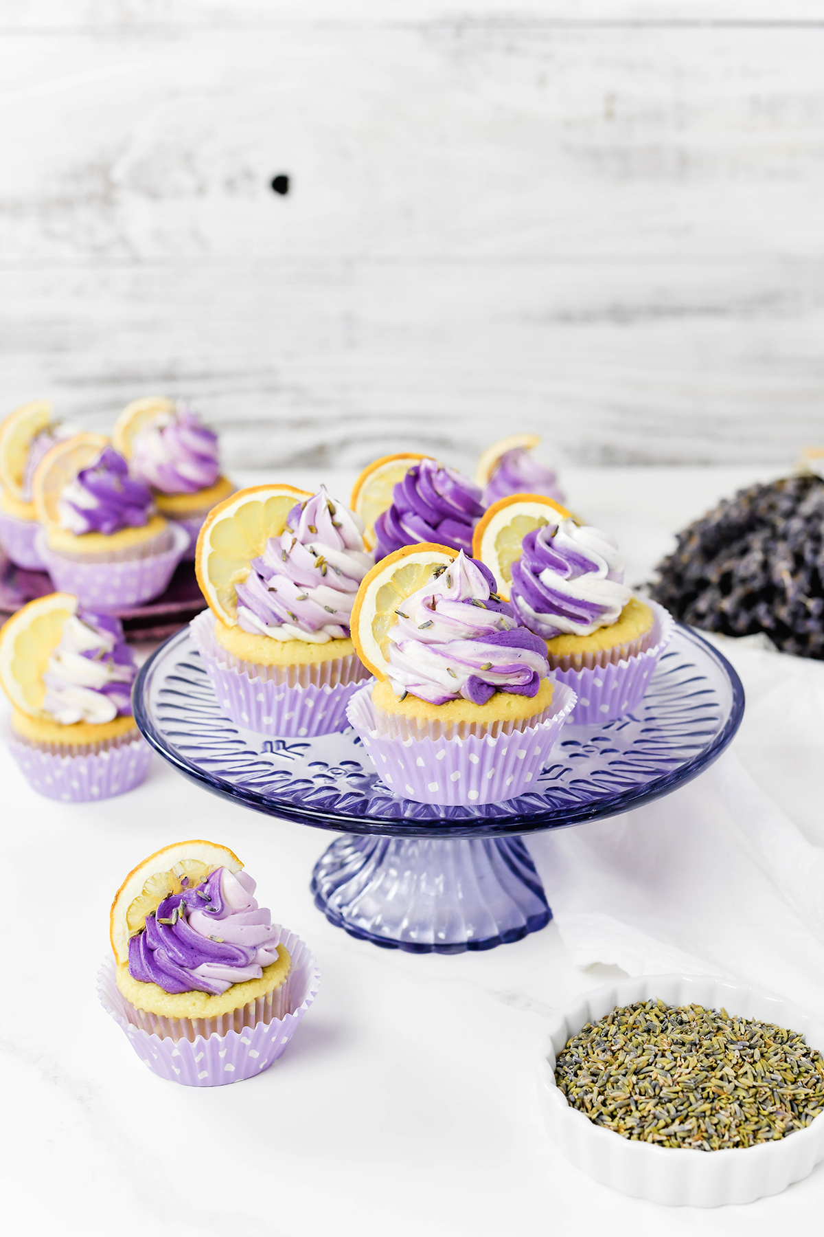 Three quarter angle of Lavender Lemon Cupcakes on a lavender cake stand.
