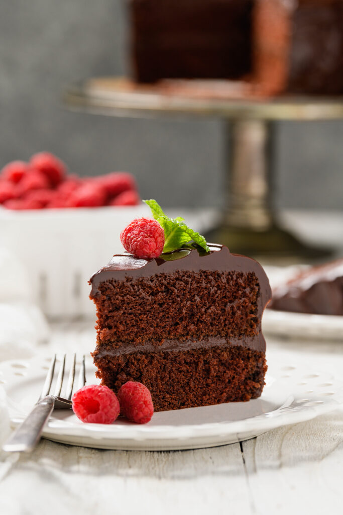 Head on angle of sliced Old-fashioned Chocolate Cake sliced on white plate.