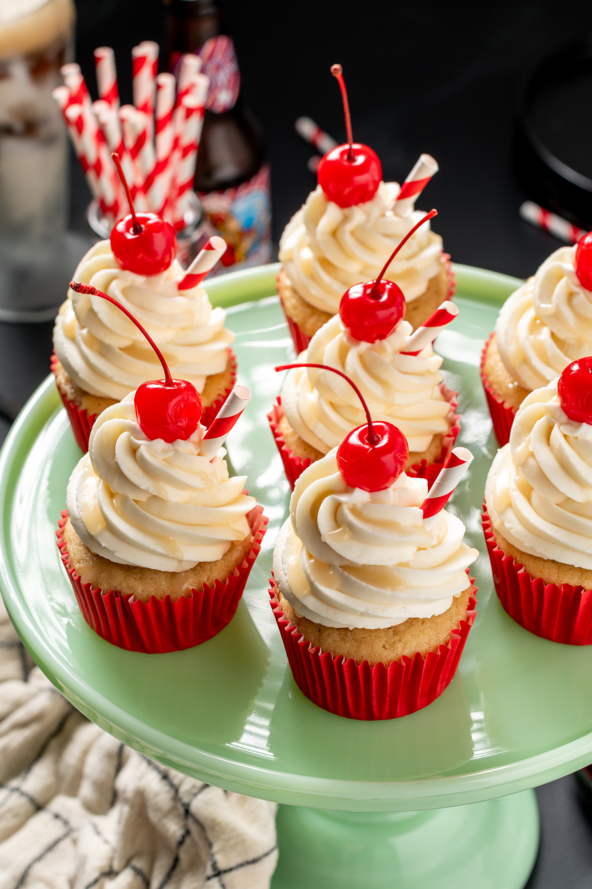 Three quarter angle of Root Beer Float Cupcakes on a green cake stand.