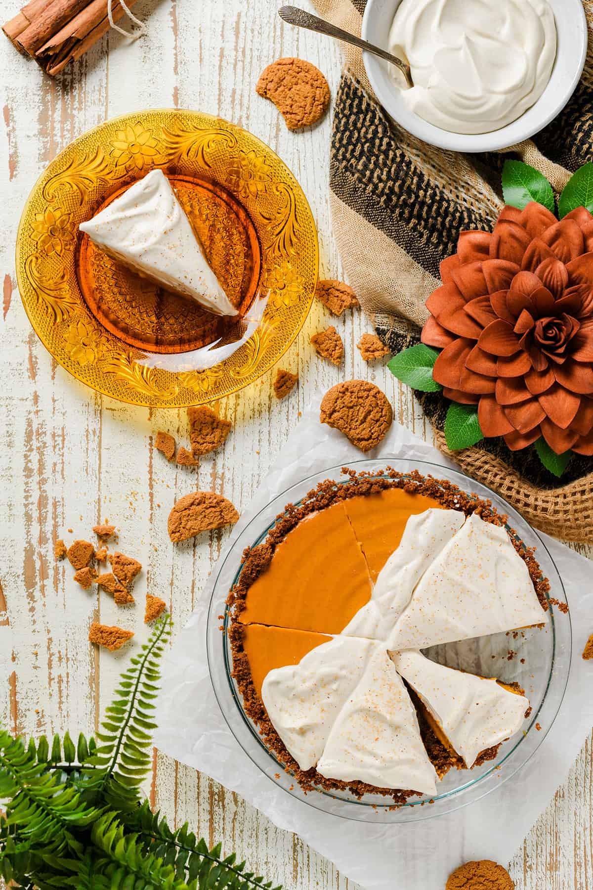 Overhead shot of sliced Pumpkin Pie with Gingersnap Crust with one slice on an orange antique plate.