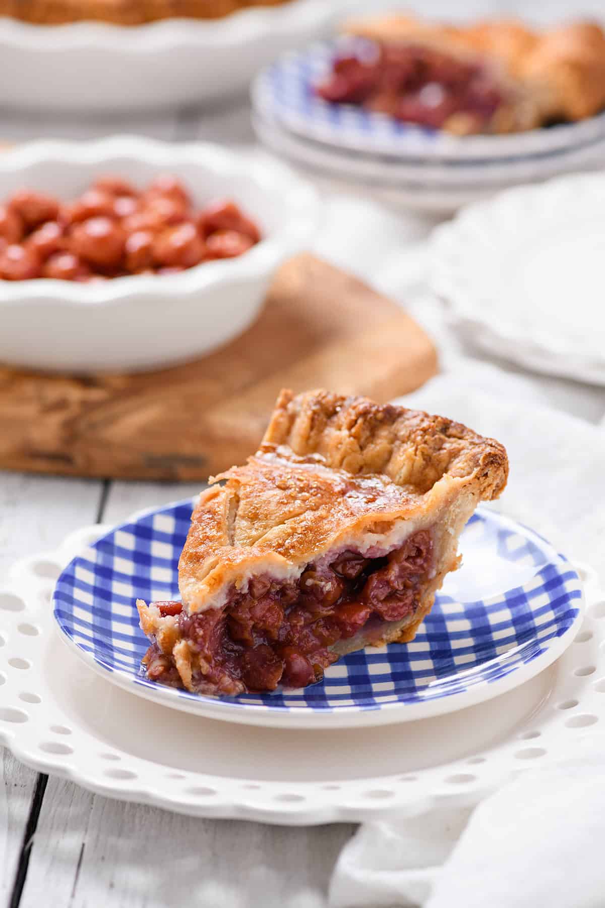 Three quarter angle of sliced Easy Cherry Pie on blue gingham plate.