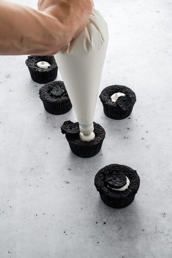 Three quarter angle of filling the Black Velvet Halloween Cupcakes.