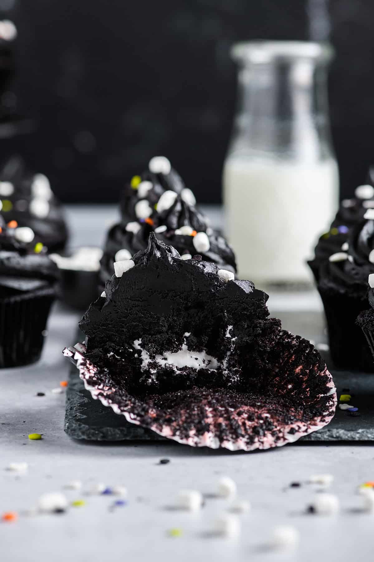 Close up shot of bitten Black Velvet Halloween Cake with marshmallow filling.