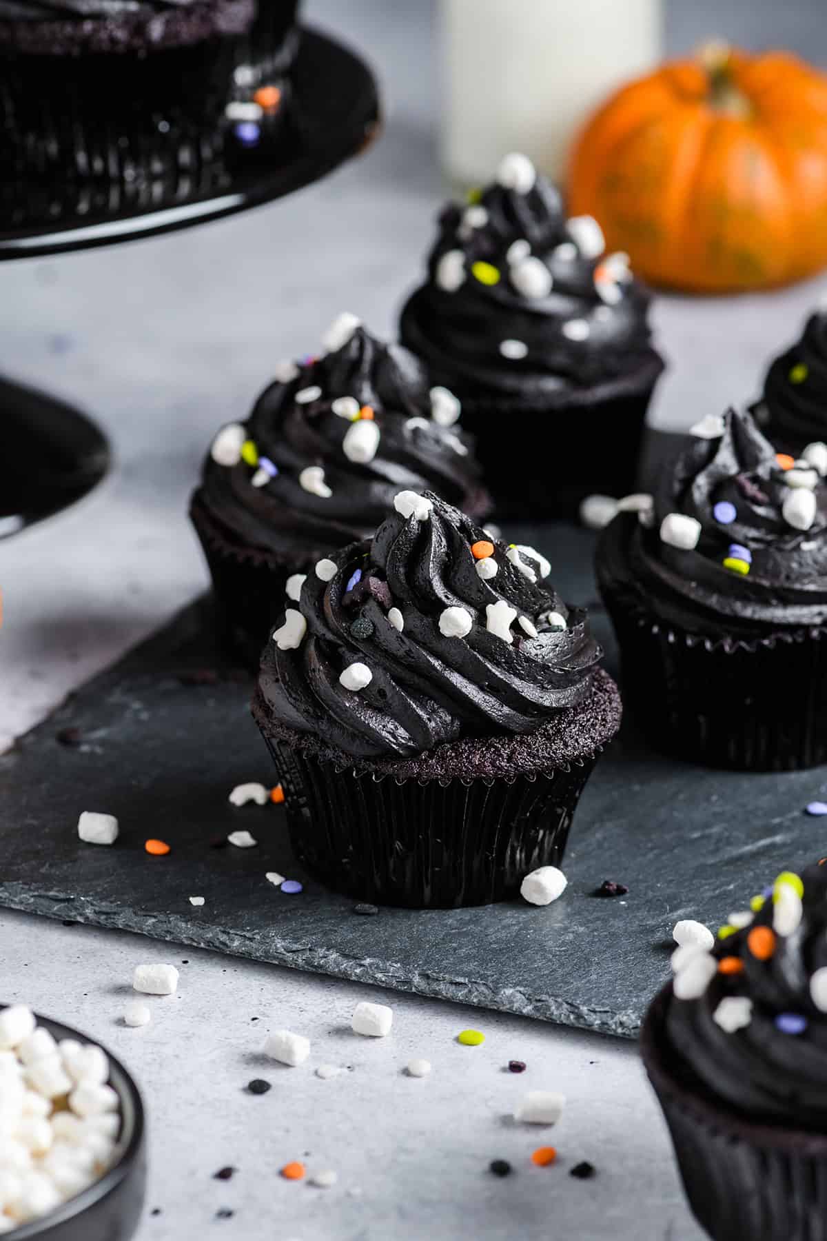 Three quarter angle of Black Velvet Halloween Cupcakes on slate serving plate.