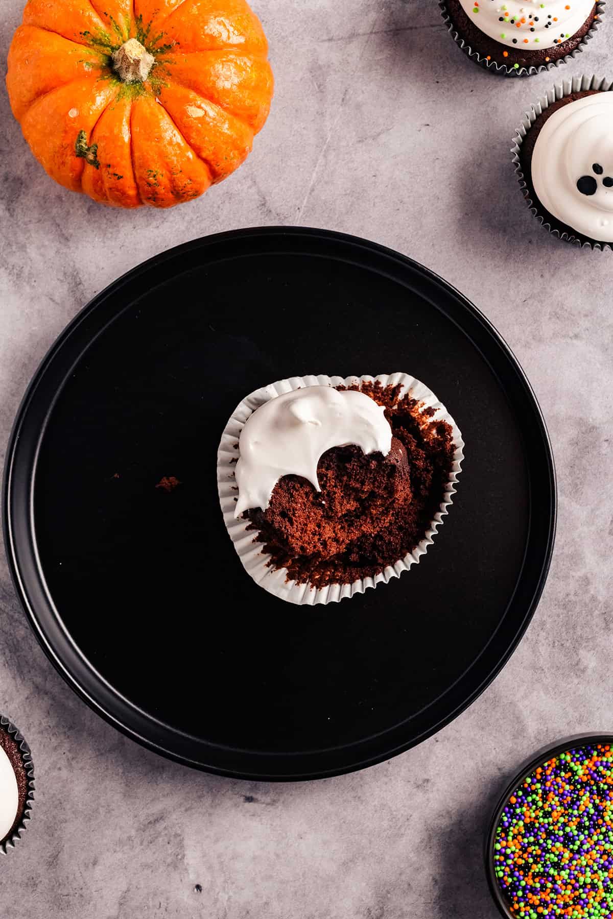 Overhead image of Devil's Food Ghost Cupcake with bite.