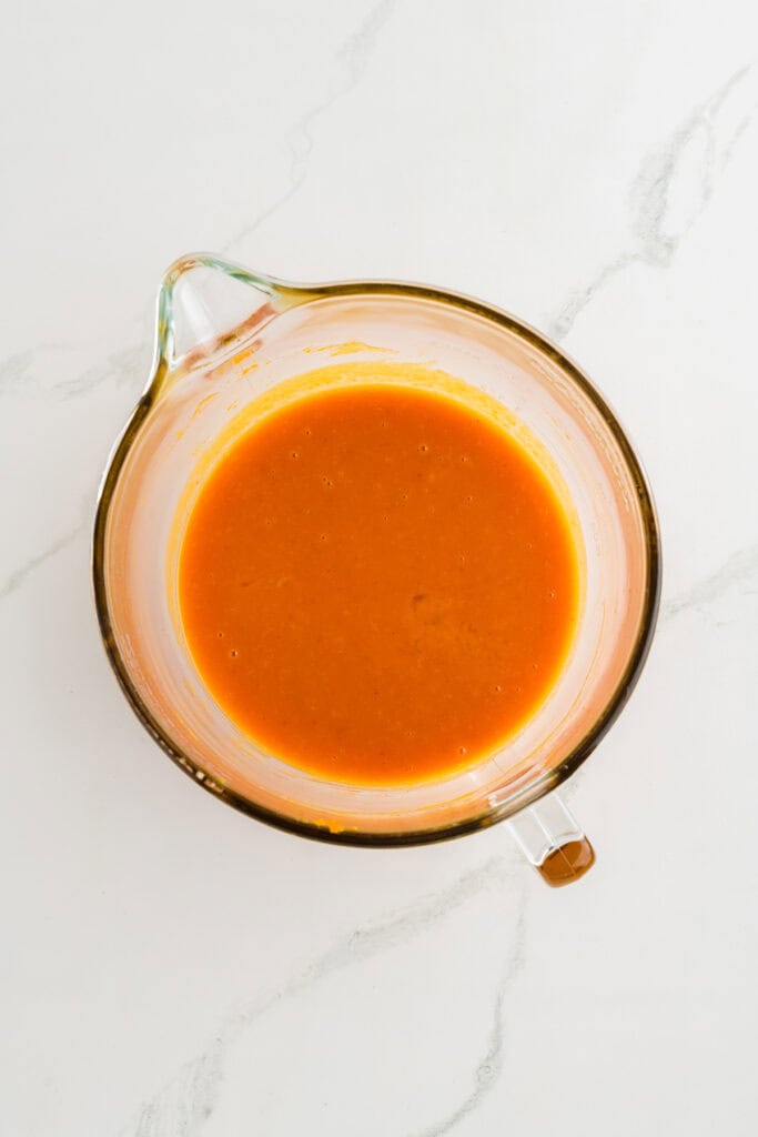 Overhead shot of wet ingredients for Pumpkin Spice Layer Cake with Caramel Cream Cheese Frosting.