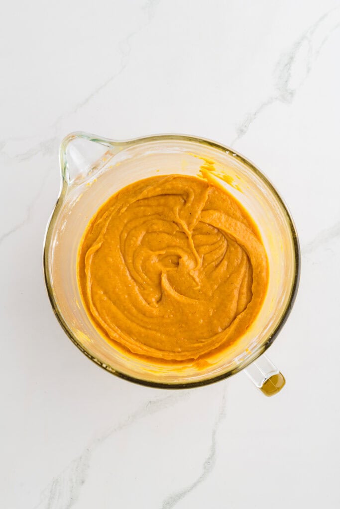 Overhead shot of completed cake batter for Pumpkin Spice Layer Cake with Caramel Cream Cheese Frosting.
