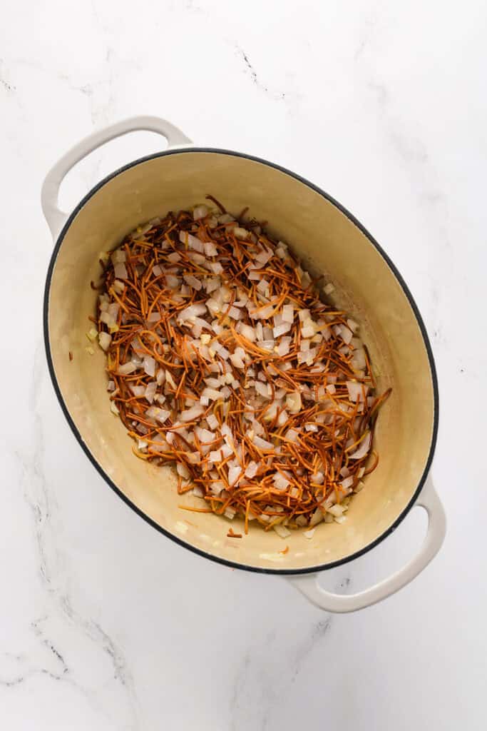 Overhead shot of fried fideo with cookies onions and garlic for Chicken Fideo Soup.