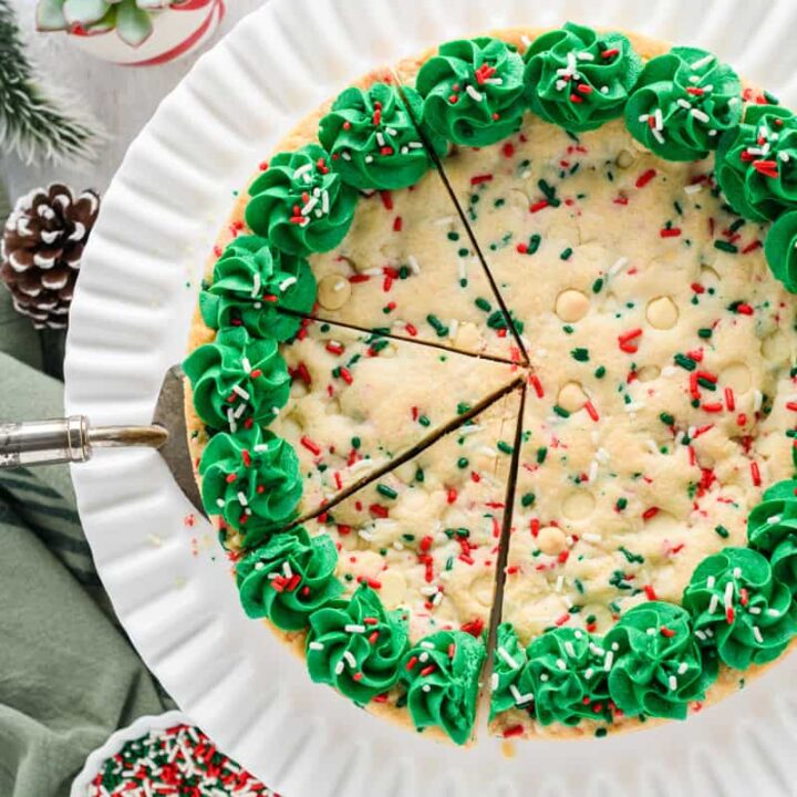 Overhead shot of Christmas Confetti Cookie Cake sliced in three with cake server.