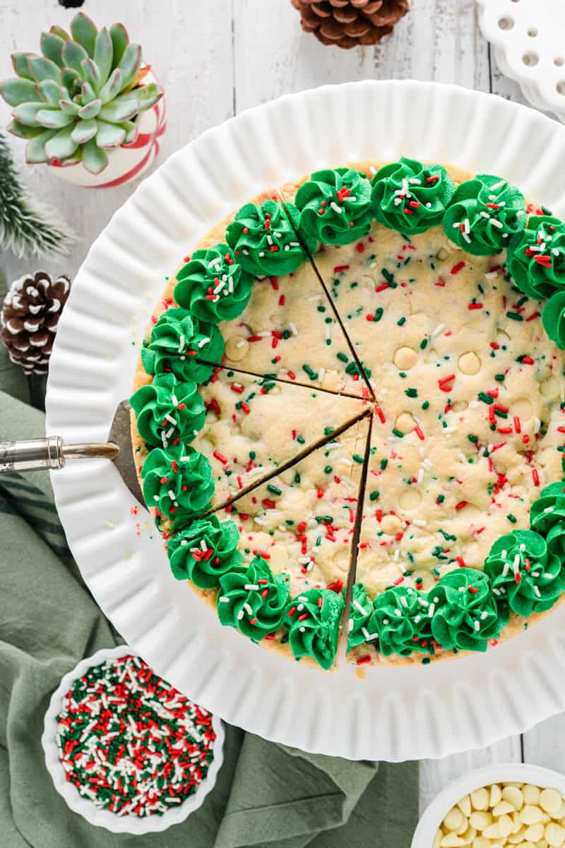 Overhead shot of Christmas Confetti Cookie Cake sliced in three with cake server.
