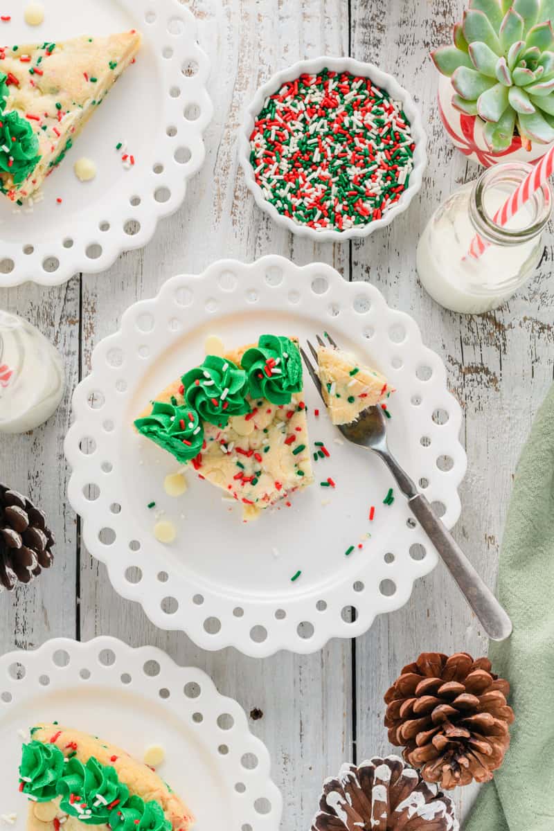Overhead shot of slices of Christmas Confetti Cookie Cake with fork and sprinkles.
