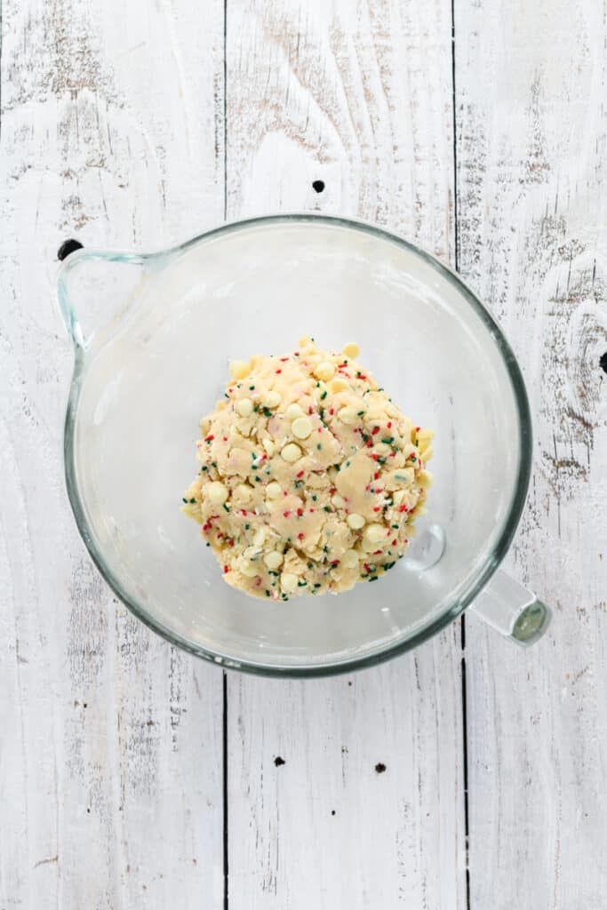 Overhead shot of Christmas Confetti Cookie Cake dough with sprinkles and white chocolate chips.