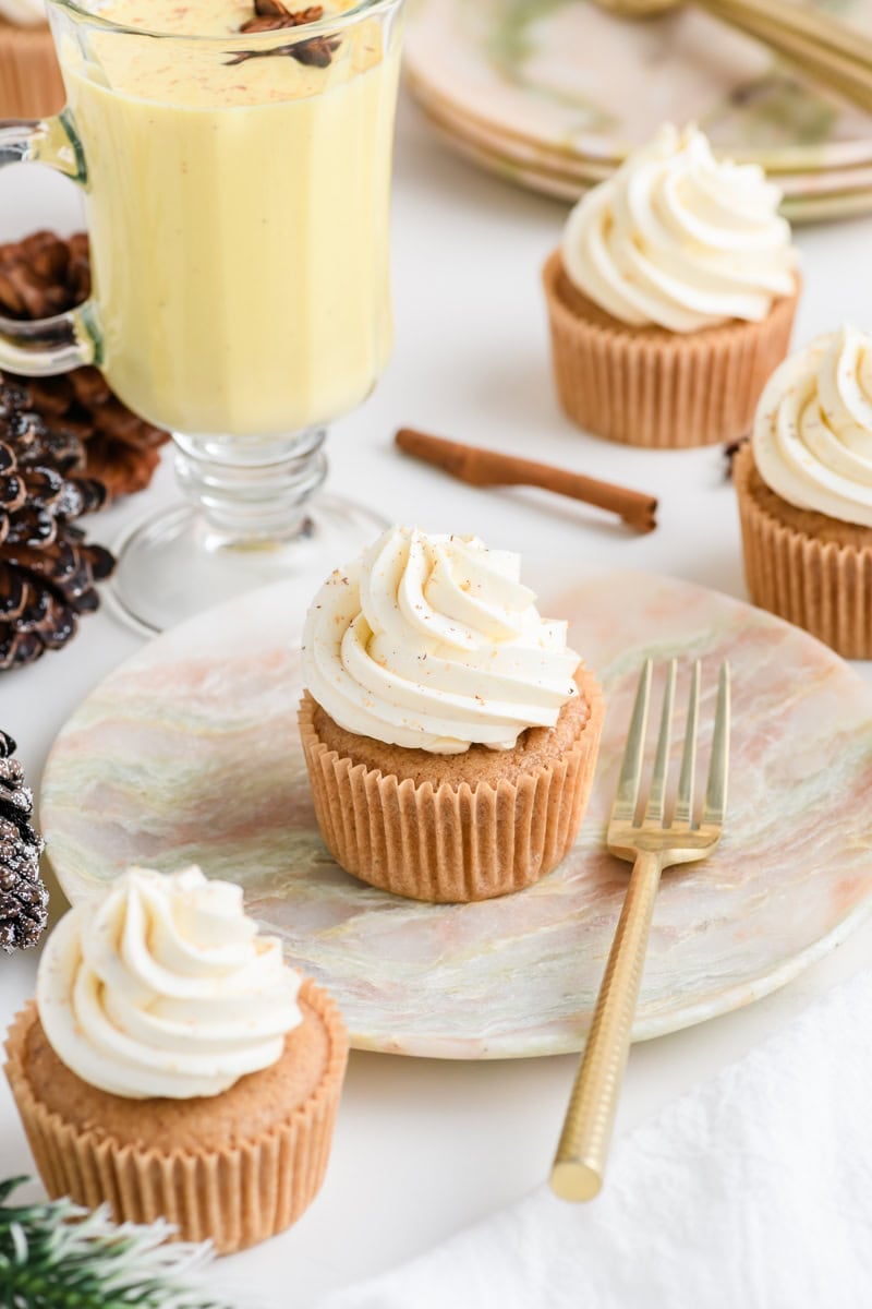 Angled shot of Eggnog Cupcake on a plate with fork.