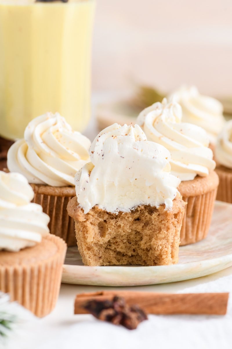 Close up of Eggnog Cupcakes on a plate with a bite removed.