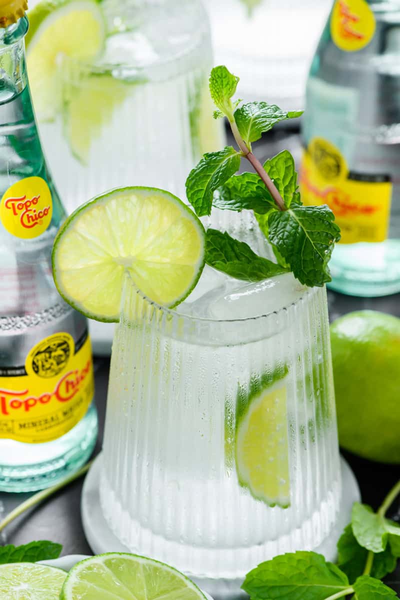 Angled close up shot of one Hangover Cure with one in the background with a couple of Topo Chico bottles around.