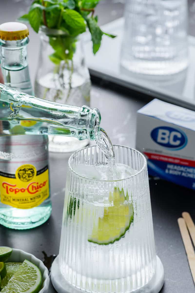 Action shot of Topo Chico being poured into a glass for Hangover Cure recipe.