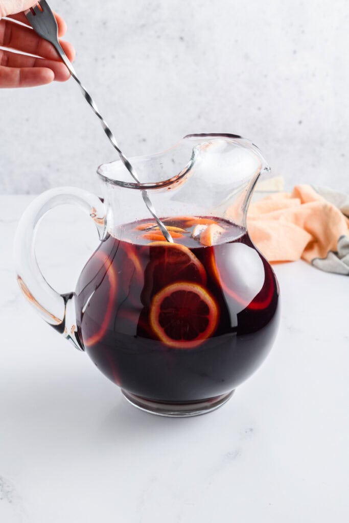Process shot of ingredients combined in a pitcher for Simple Sangria.