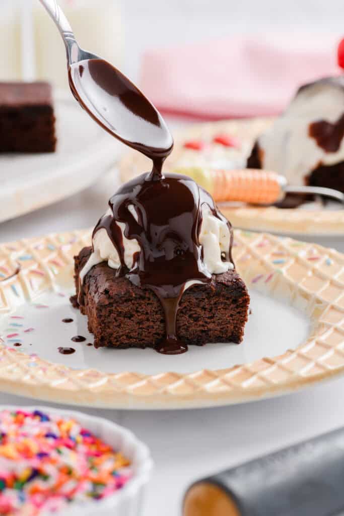 Close up shot of chocolate sauce being poured over Lightened Up Brownie a la Mode.