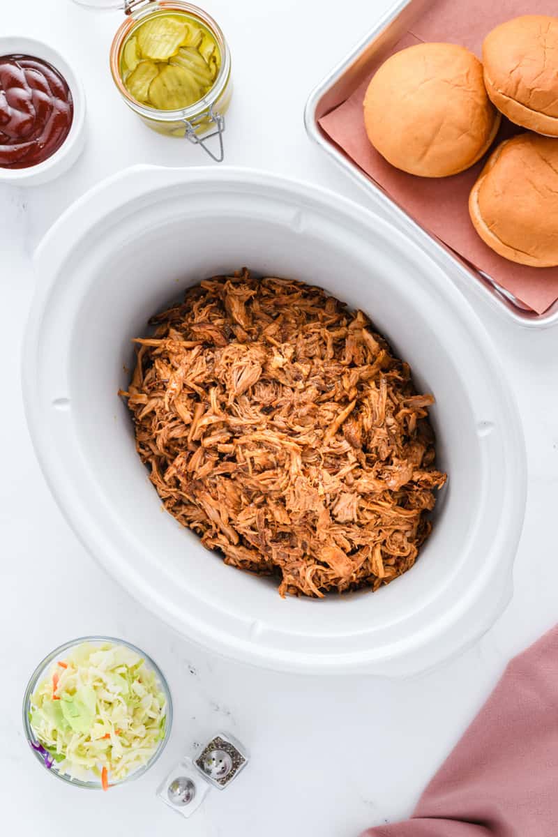 Overhead shot of pulled pork in slow cooker for Slow Cooker Pulled Pork Sandwiches.