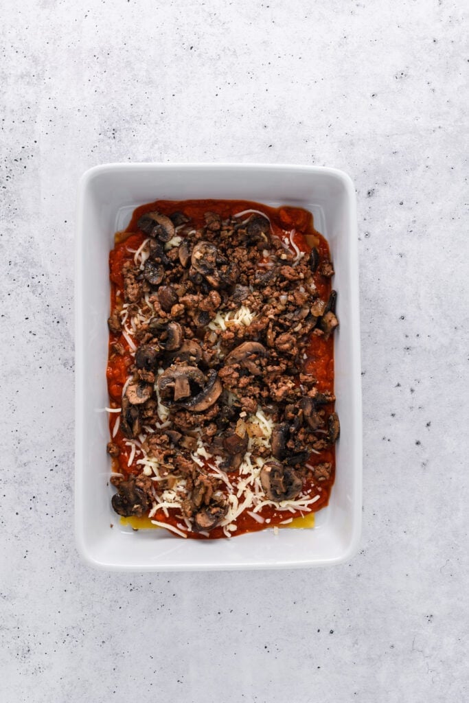 Overhead shot of lasagna layering for Easy Sausage and Mushroom Lasagna step 5.