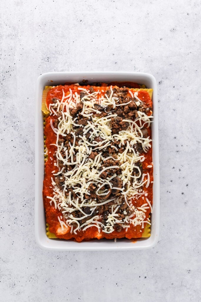 Overhead shot of lasagna layering for Easy Sausage and Mushroom Lasagna step 6.