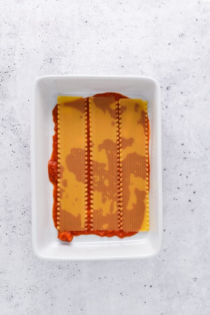 Overhead shot of lasagna layering for Easy Sausage and Mushroom Lasagna step 1.