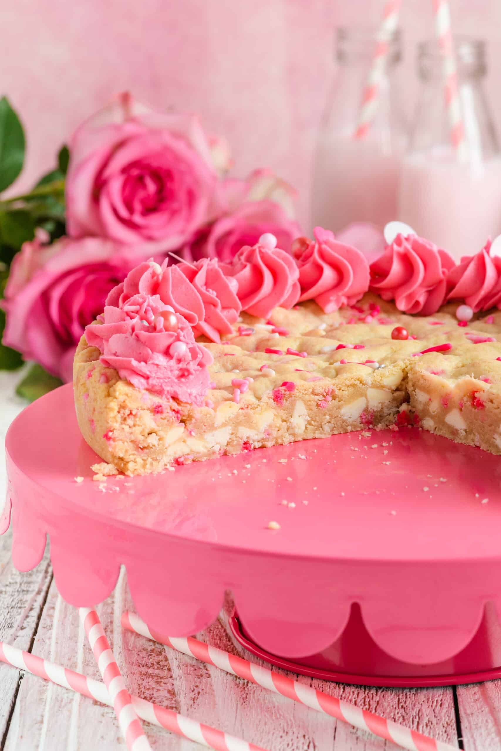 Close up shot of sliced Valentine Confetti Cookie Cake on pink pedestal.