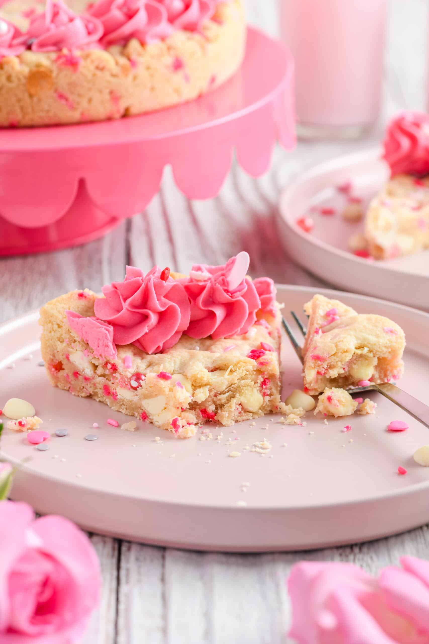 Close up shot of bite removed from slice of Valentine Confetti Cookie Cake.