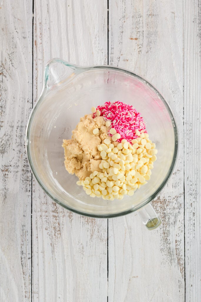Overhead shot of cookie dough with white chocolate chips and sprinkles for Valentine Confetti Cookie Cake.