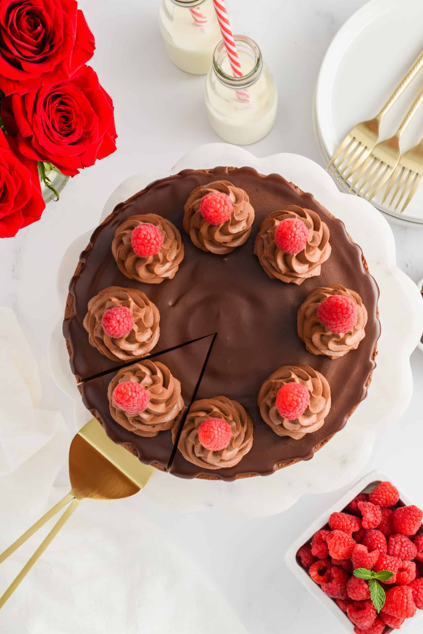 Overhead shot of Chocolate Raspberry Cake with Whipped Ganache Frosting with a slice cut with cake server.