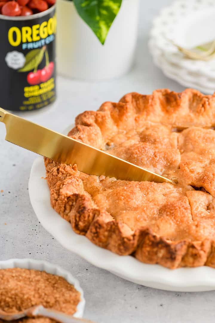 Angled image of knife cutting into Easy Cherry Pie.