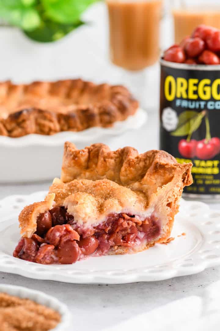 Close up shot of sliced Easy Cherry Pie served on a white plate.