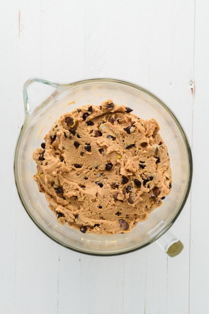 Overhead shot of chocolate chips and Easter candy combined in Easy Easter Chocolate Chip Cookie dough.