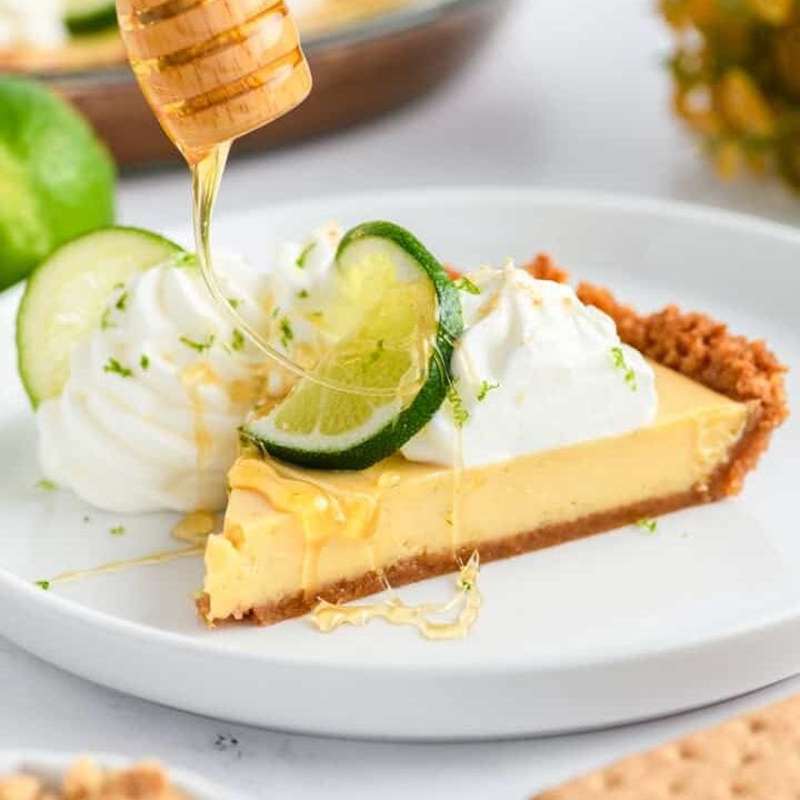 Sliced Key Lime Pie with honey being drizzled on top.