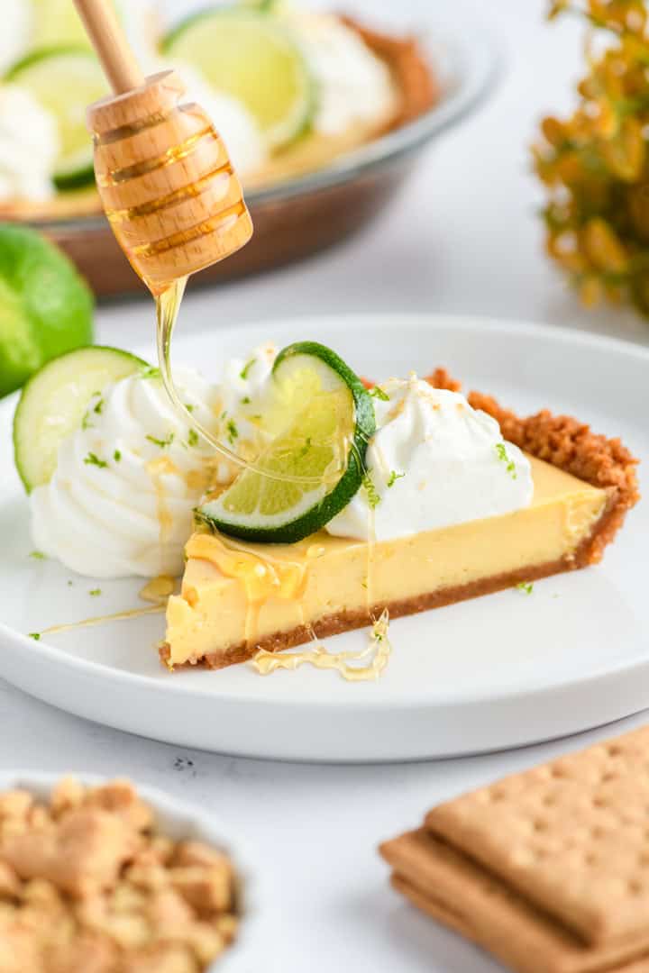 Sliced Key Lime Pie with honey being drizzled on top.
