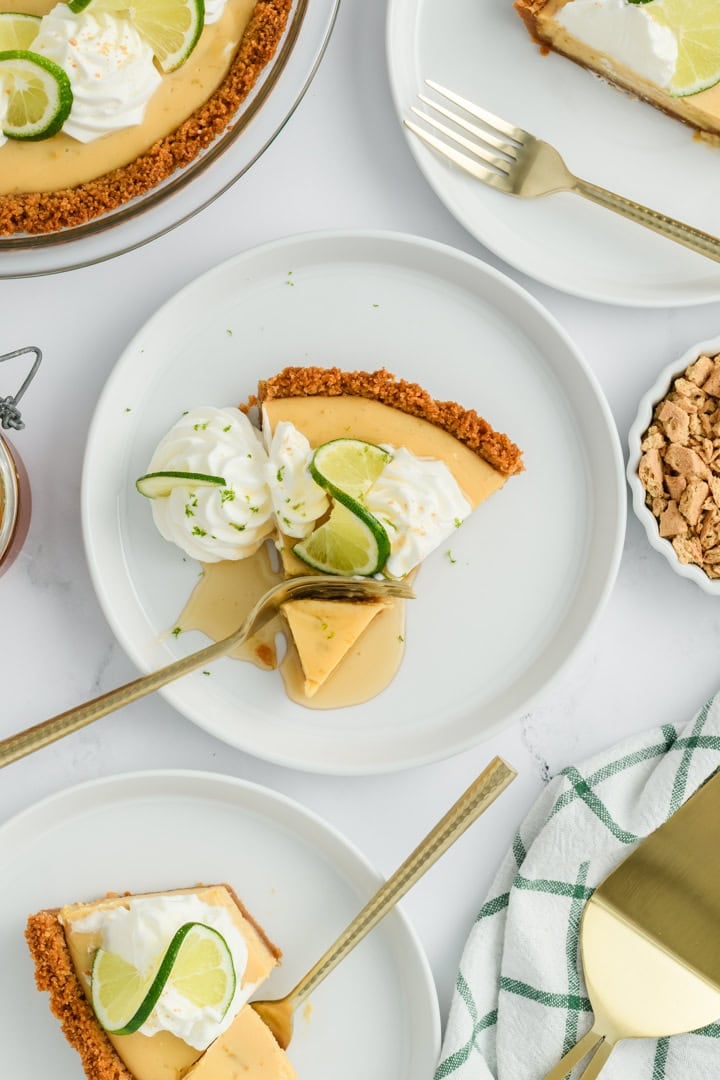 Overhead shot of Key Lime Pie slice with honey and fork cutting through it.